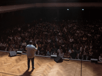 Benjamin on stage in front of a full theatre